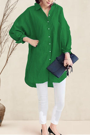 Oversized linen shirt in green with button-up front and long sleeves styled with white pants and black heels
