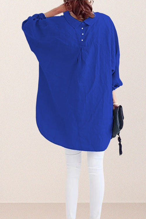 Back view of oversized linen shirt in blue with button and gather detail, paired with white pants