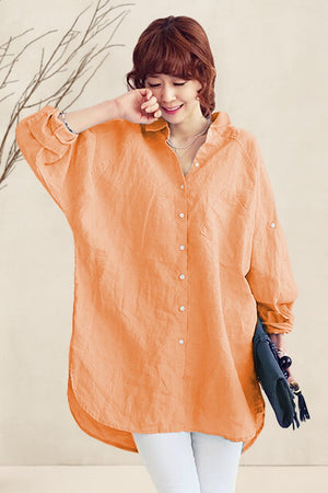 Woman wearing an oversized orange linen shirt with loose sleeves and button front