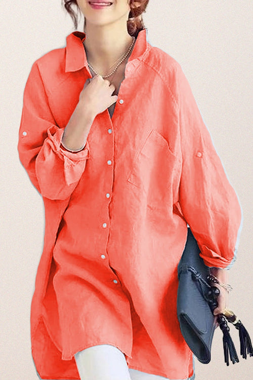 Coral oversized linen shirt with relaxed fit and button details, styled casually with rolled sleeves and a black clutch bag