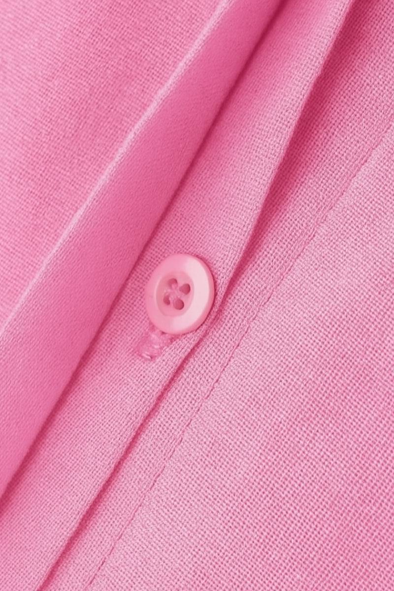 Close-up of pink oversized 100% cotton shirt fabric and button detail