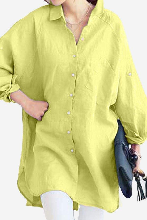 Yellow oversized linen shirt with long sleeves and buttons, styled casually with a clutch bag.