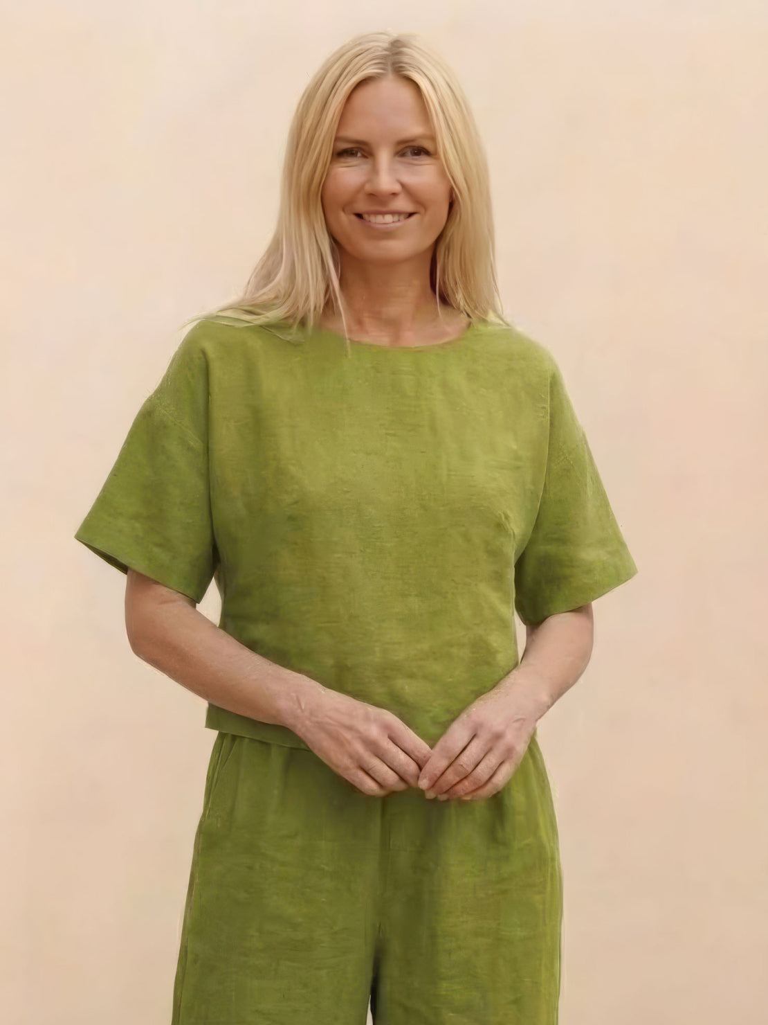 Woman wearing green loose fit co-ord set with short sleeves and wide-leg pants against a neutral background