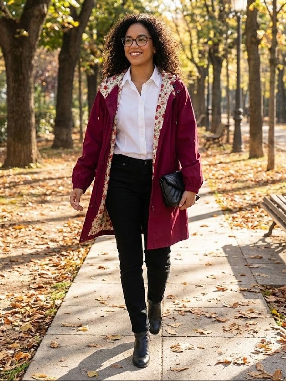 Woman walking in park wearing burgundy Rain Couture Windbreaker with floral lining over white shirt and black pants