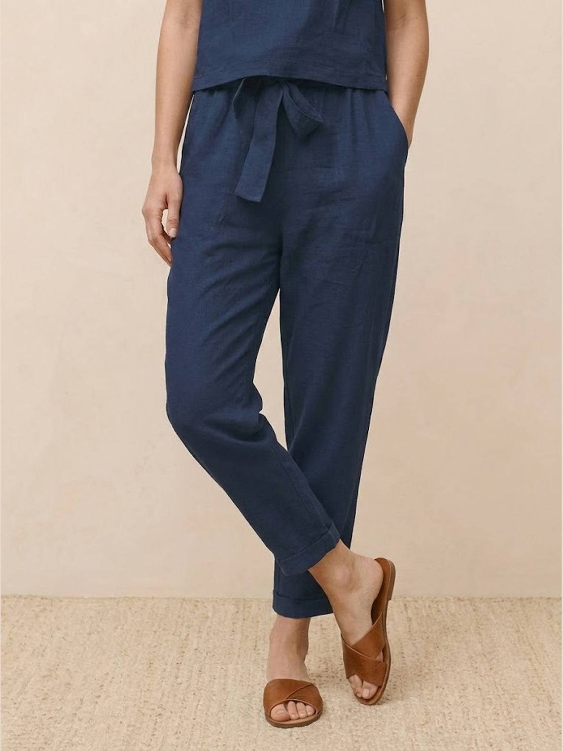 Woman wearing relaxed 100% cotton linen set with short-sleeve top and straight-leg pants.