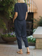 Woman wearing relaxed cotton linen set with short-sleeve top and straight-leg pants in monochrome tone