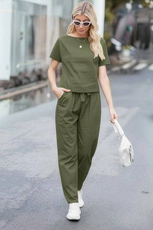 Woman wearing olive green cotton linen set two-piece outfit with short sleeve top and straight-leg pants on street