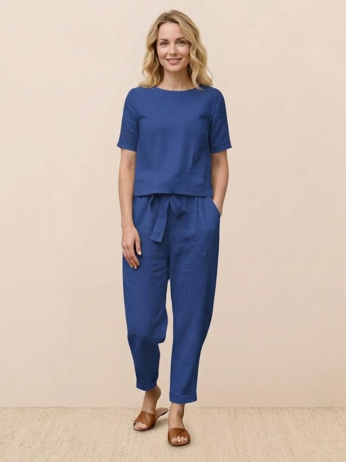 Woman wearing relaxed 100% cotton linen set with monochrome short-sleeve top and straight-leg pants on white background