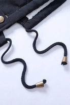 Close-up of black drawstrings with metal tips on thick long-sleeve zipper overcoat