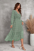 Woman wearing green floral Bloom Wrap Midi Dress with A-line silhouette and trumpet sleeves