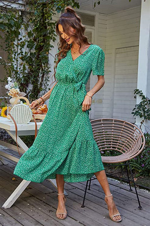 Woman wearing green charming floral boho maxi dress with wrap V-neck and belted ruffle hem outdoors