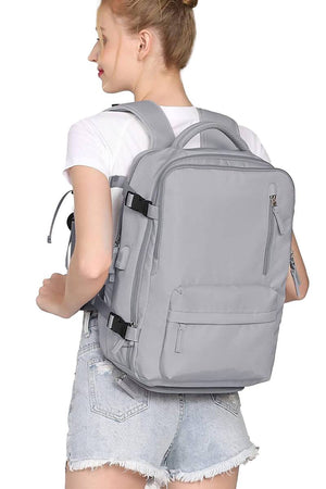 Chic Wanderlust Waterproof Backpack in gray worn by woman, durable and spacious travel backpack with multiple compartments