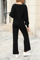 Woman wearing black round neck loose fit cozy two-piece set with wide-leg pants and white sneakers outdoors