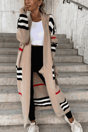 woman wearing cozy striped long knitted cardigan with oversized fit and long silhouette on stairs