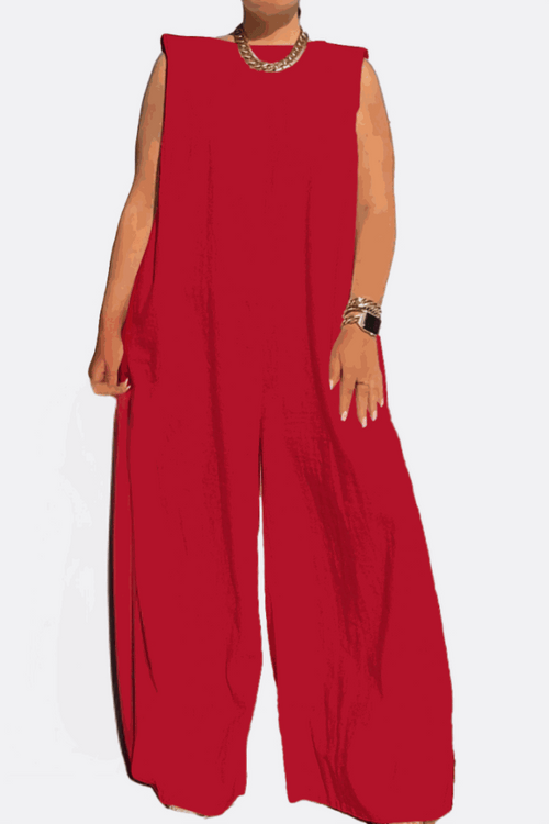 Red sleeveless wide-leg jumpsuit with a relaxed fit and sharp shoulder details, styled with gold accessories.