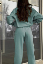 Woman wearing a cotton-blended two-piece tracksuit in light teal, shown from the back.