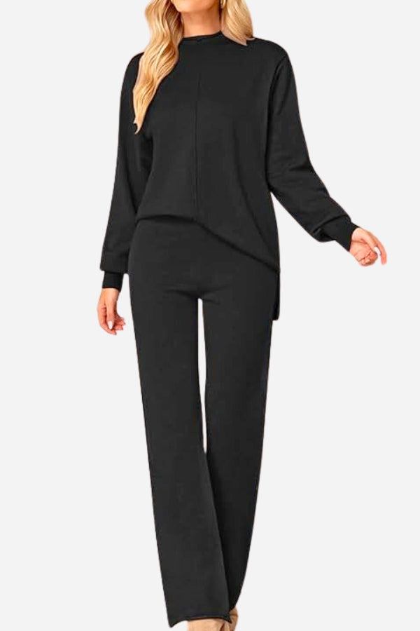 Woman wearing a black high neck sweater and wide leg pant set with long sleeves and knit cuffs