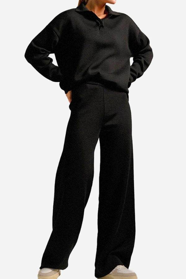 Woman wearing a black plush and preppy two-piece travel set with wide-leg pants and a polo collar pullover