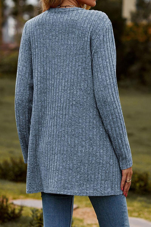 Back view of a woman wearing a long, lightweight, ultra soft knit-like gray cardigan outdoors