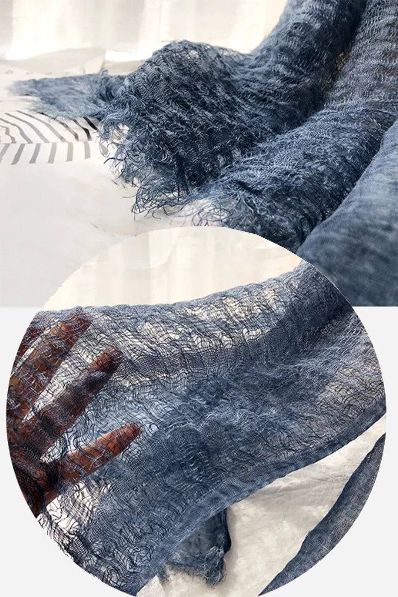 Close-up of lightweight blue linen scarf with frayed edges showing breathable fabric texture