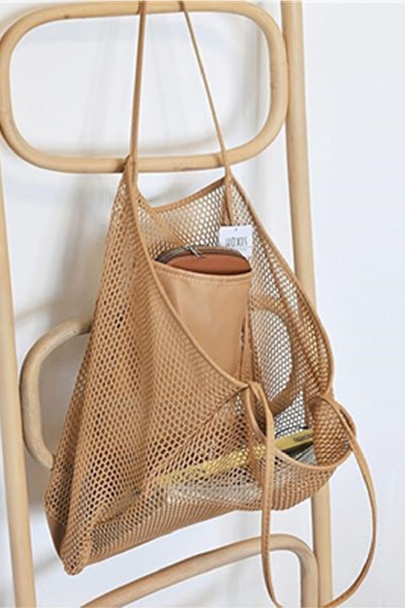 Breezy mesh tote bag in beige hanging on chair with items inside, lightweight and foldable travel bag