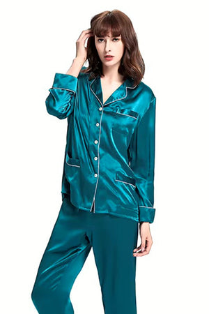 Woman wearing long sleeve silk pajamas in teal with button-up top and matching pants
