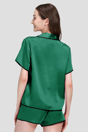 Woman wearing green mulberry silk hemd trimmed pajama set with black hems back view
