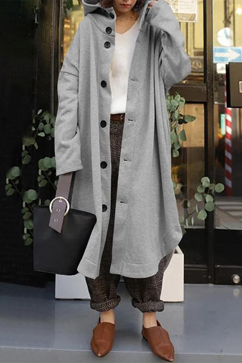 Woman wearing oversized everyday buttoned hooded coat in light gray with black buttons and casual outfit