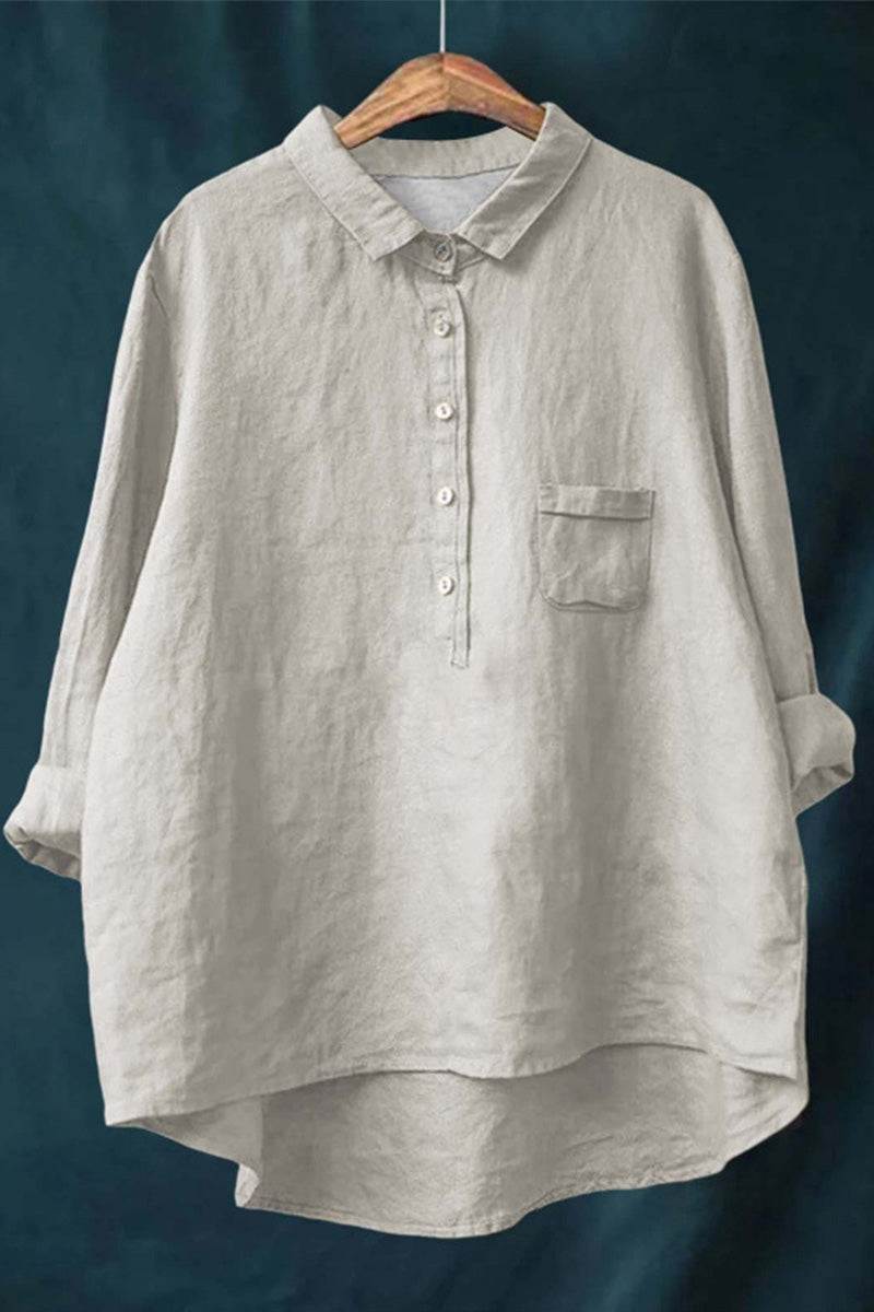 Light beige vintage linen shirt with half-button front and chest pocket hanging on wooden hanger