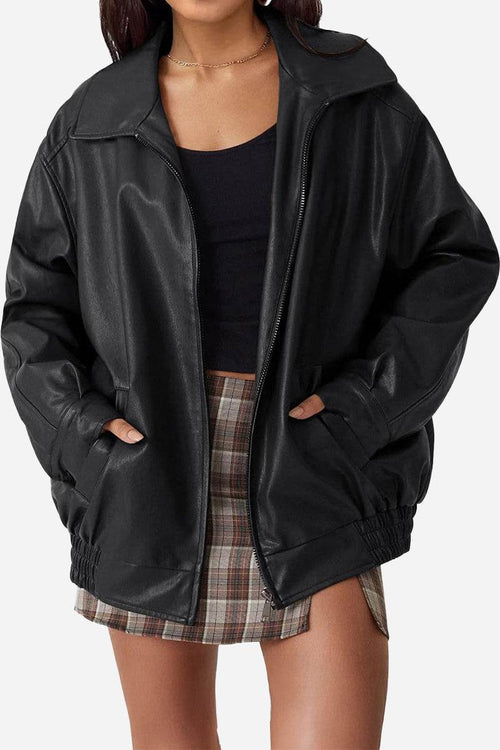 Oversized black faux leather motorcycle jacket with a relaxed fit worn over casual outfit