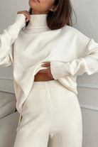 Woman wearing a white knitted turtleneck two-piece set with long sleeves and wide-leg pants
