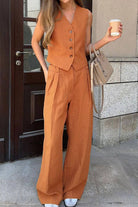 woman wearing eco chic linen blend rust-colored two-piece vest and wide-leg pants outfit holding coffee cup and beige handbag outdoors