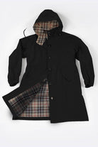 Travel-smart waterproof hooded windbreaker with black exterior and beige plaid lining, breathable fabric, adjustable hood, and sealed zippers for rain protection.