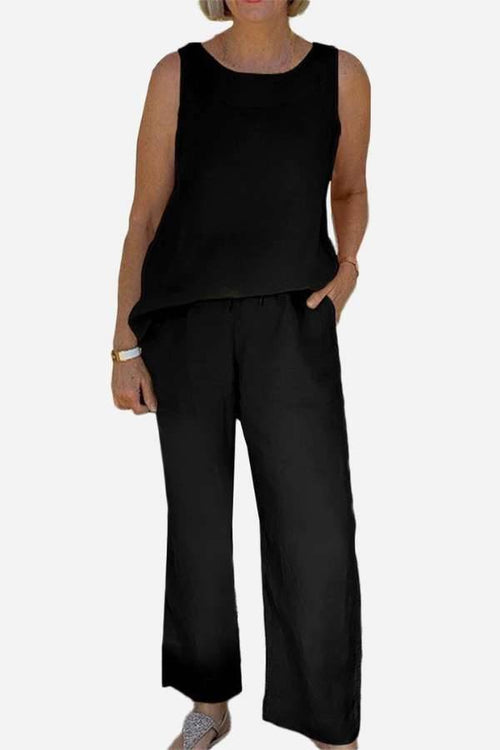 Woman wearing a black sleeveless sleek silhouette coordinated set with wide-leg pants and a relaxed fit top.