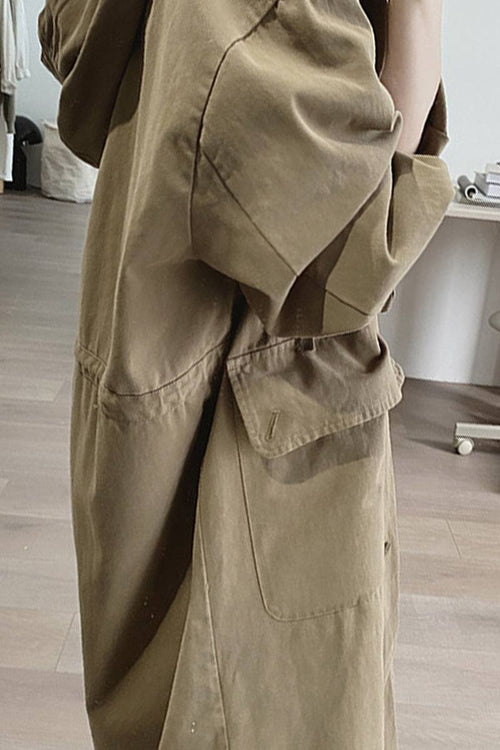Brown travel-ready hooded windbreaker with oversized fit and snap-button pockets