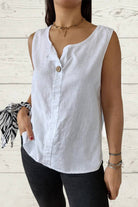White 100% pure linen sleeveless cool comfort vest with V-neck and button detail, worn with black pants.