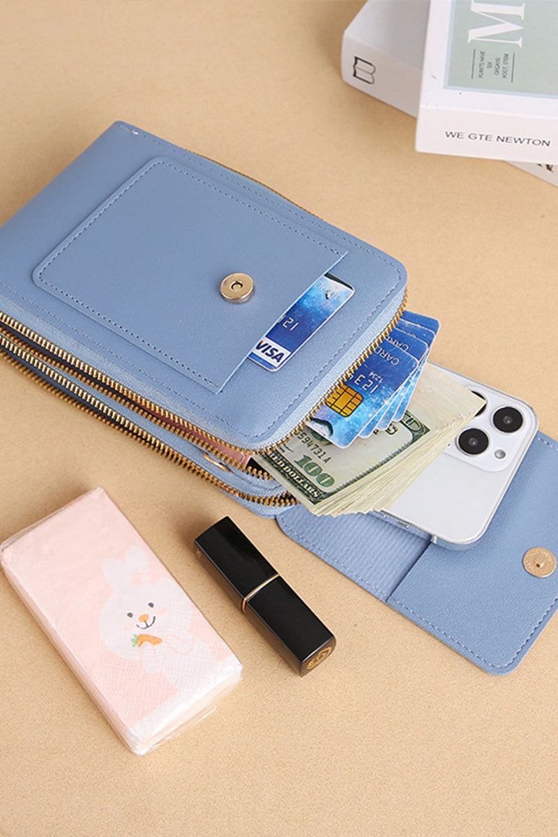 Blue anti-theft travel crossbody phone pouch holding smartphone, cash, cards, and lipstick on beige surface