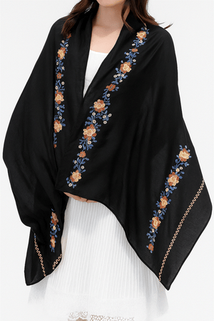 Black embroidered travel-must shawl wrap with floral design worn over white dress