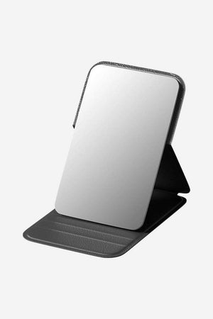Compact travel pocket mirror with durable black PU leather case and clear reflective glass surface, lightweight and portable for on-the-go use.