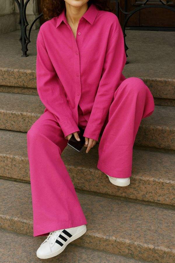 Woman wearing vibrant raspberry red 100 cotton Wanderlust two-piece set with relaxed fit sitting on steps