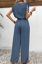 Back view of elegant two-piece set in blue with lace detail and wide-leg pants outdoors