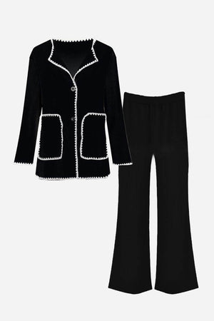 Black contrast-trim knit cardigan with matching black knit pants set laid flat.