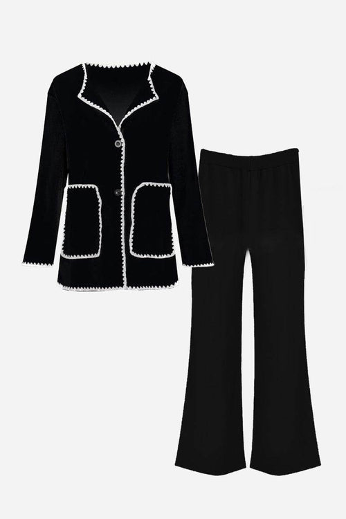 Black contrast-trim knit cardigan with matching black knit pants set laid flat.