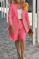Woman wearing a stylish pink blazer and shorts two-piece set with a white top and a large yellow flower accessory