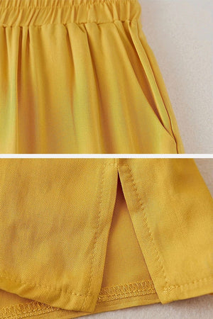 Close-up of mustard yellow breathable cotton wide-leg pants from 100 cotton two-piece set with elastic waistband and side slit hem detail