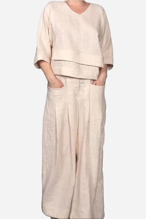 Woman wearing Atelier Serenity layered two-piece set in neutral beige with relaxed fit and wide-leg trousers