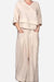 Woman wearing Atelier Serenity layered two-piece set in neutral beige with relaxed fit and wide-leg trousers