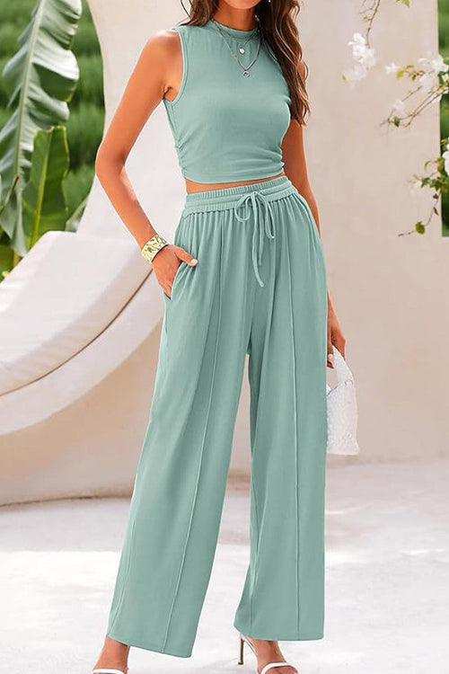 Woman wearing a Stroll & Hangout Ribbed Knit two-piece set with sleeveless crop top and wide-leg pants in light green.