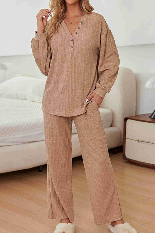 Woman wearing beige Desert Bloom Ribbed Comfort Set with V-neck ribbed top and wide-leg pants in a cozy bedroom.