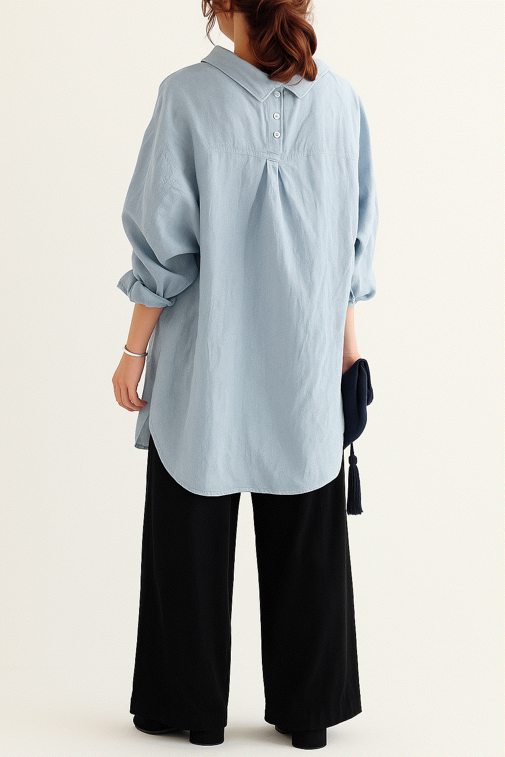 Woman wearing a light blue linen-cotton blend oversized shirt and black high-waist palazzo pants from the Linen Breeze Set.